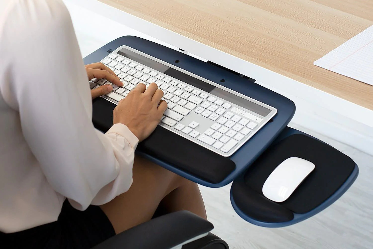 a woman sitting at a desk using a keyboard