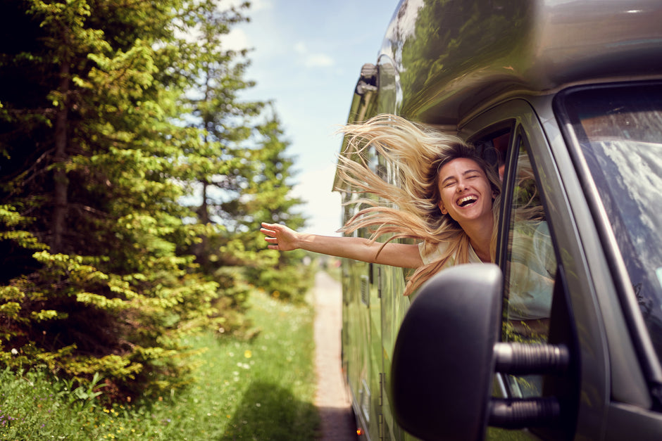 a woman is hanging out of the window of a car