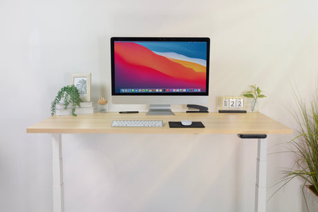 a computer monitor sitting on top of a wooden sit stand desk