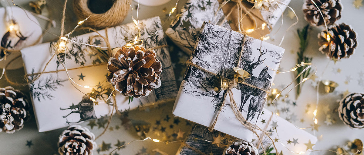 presents wrapped in white paper with pine cones on them