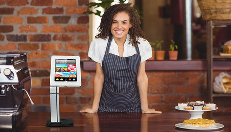 a woman standing in front of a counter with pastries on it