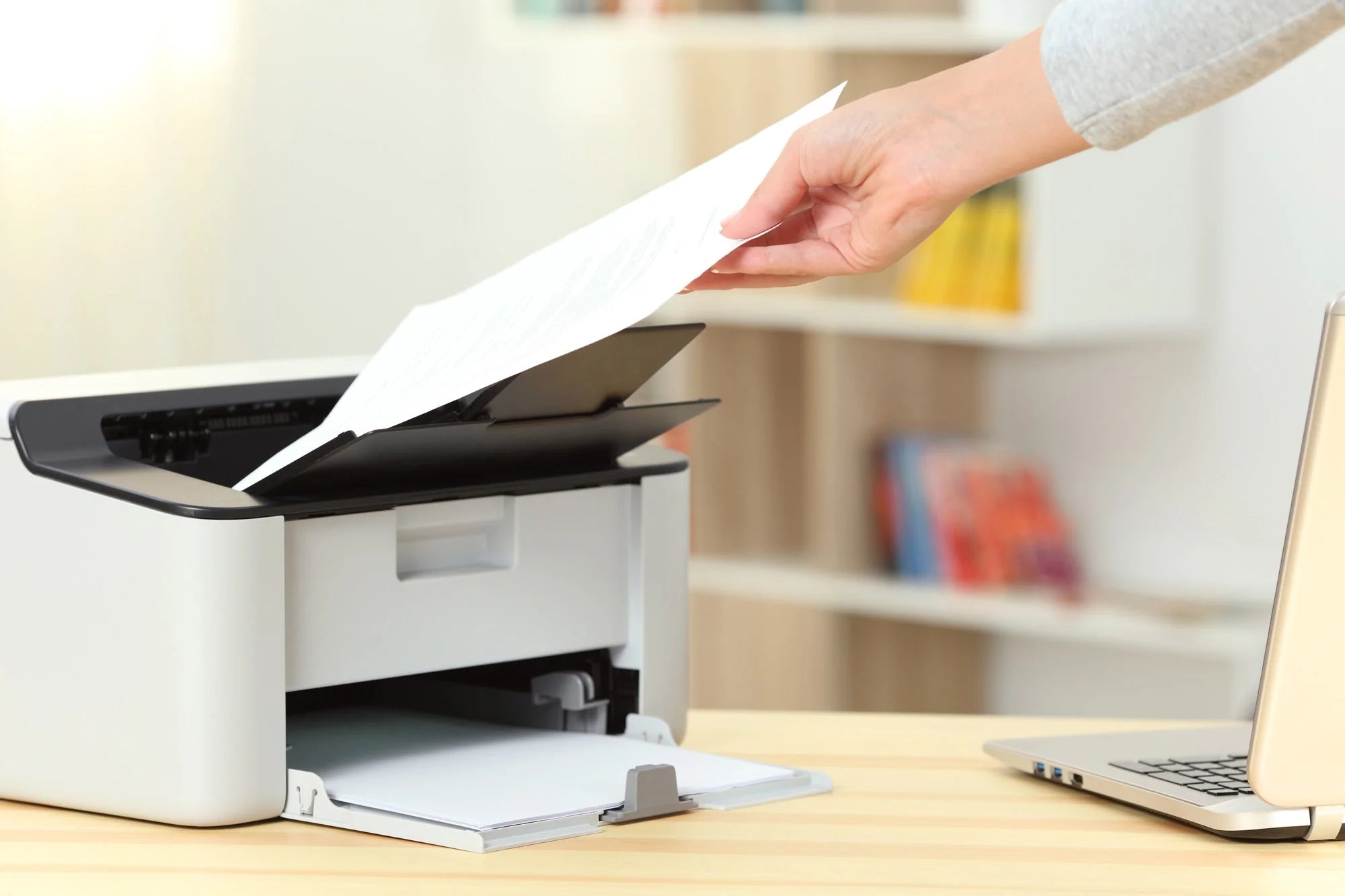 a person putting a piece of paper into a printer